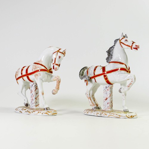 1505 - A Pair of porcelain horses in red and gilt reins on rococo bases. Crossed Swords marks to both. Grey... 