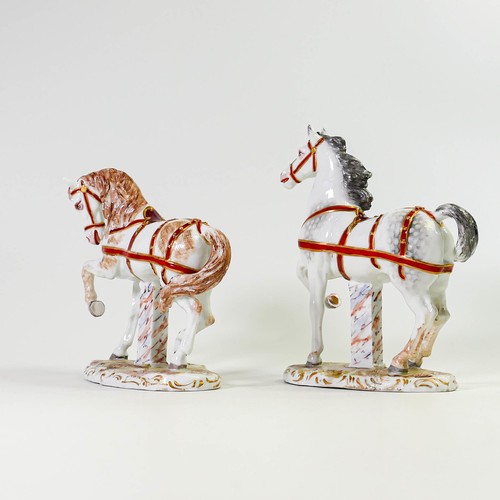 1505 - A Pair of porcelain horses in red and gilt reins on rococo bases. Crossed Swords marks to both. Grey... 