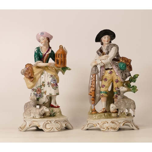 394 - A Pair of Sitzendorf Porcelain pastoral figures. Female figure pointing to open birdcage, lambs at h... 