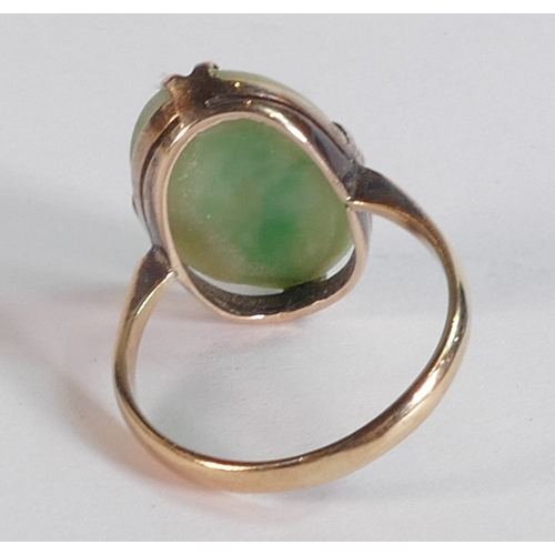 689 - 9ct gold ring set with carved Jade oval stone, ring size O/P, 4.2g.