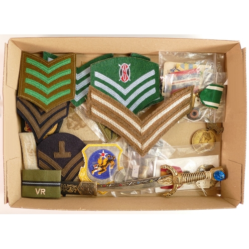 255 - A collection of military related items including cloth badges, medals etc