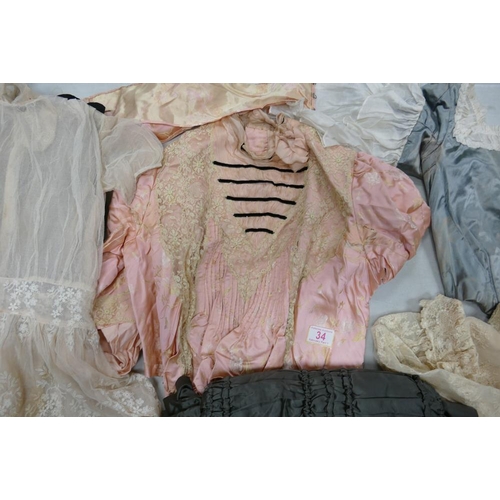 34 - A collection of antique ladies cloths to include bodice/corset with boned straps, lace child's dress... 