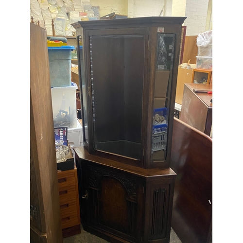 615 - Dark oak corner cabinet with carved details.