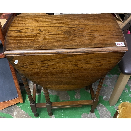 623 - Dark oak drop leaf side table raised on barley twist supports.