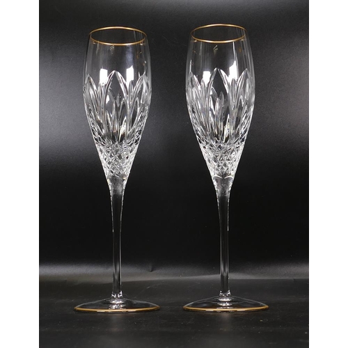 214 - two Atlantis Cut Glass Crystal Champagne Flutes with gold rims, height 16.5cm