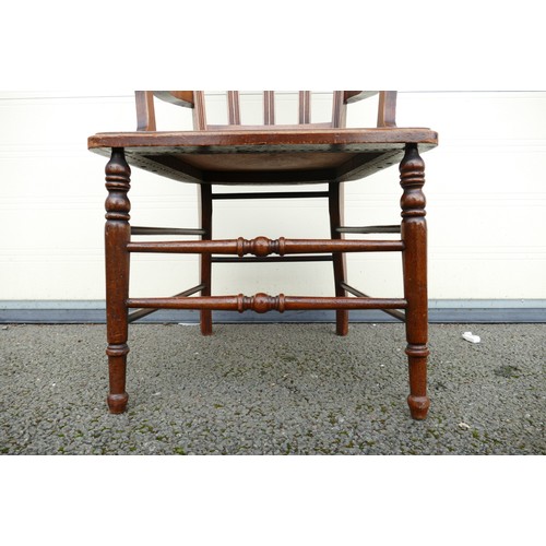 317 - An Early 20th century Armchair. Carved pediment and back with turned supports and stretcher. Panel t... 