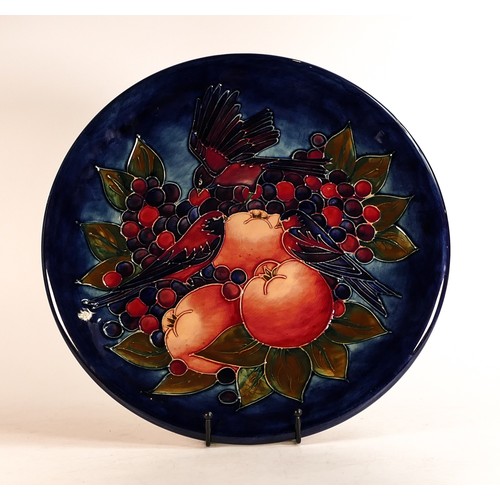 119 - Moorcroft large charger decorated in the Finch and Berries design on dark blue ground, C1990, d.35cm... 