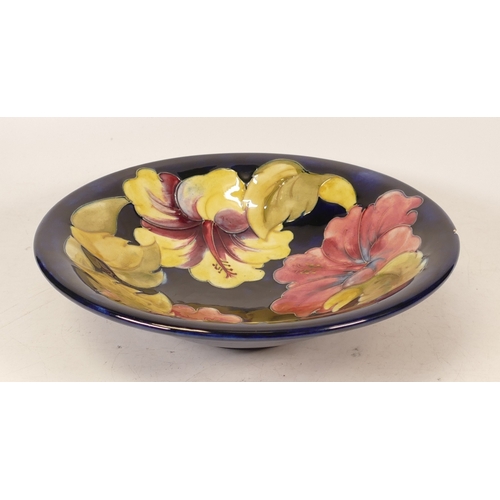 148 - Moorcroft Hibiscus on Blue Ground Shallow Footed Bowl, chip to rim, diameter 24.5cm