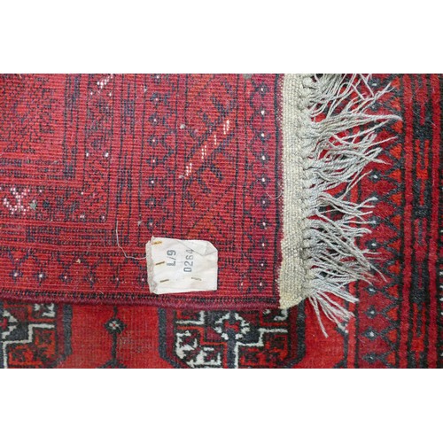 311A - A Red Afghan Floor Rug. Wear and fraying present. Length: 208cm Width: 130cm