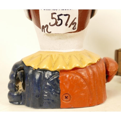 557 - Two Painted Cast Iron Money Boxes of Jesters/Clowns. One mounted on a wood and brass base (detached ... 