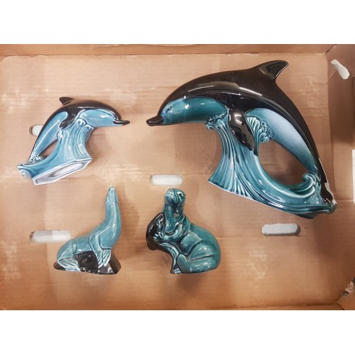 299 - Poole pottery large and small dolphins together with together with sea lion and otter (4)