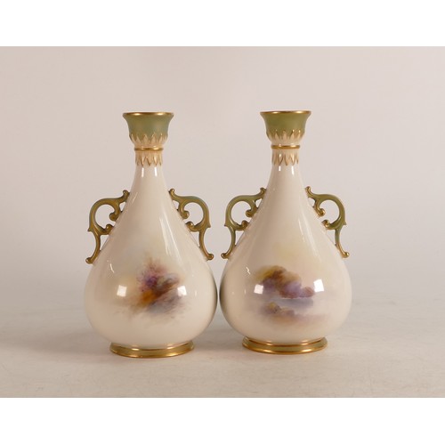 456 - A pair of Royal Worcester twin handled vases decorated in the highland cattle design. Stamped to bas... 