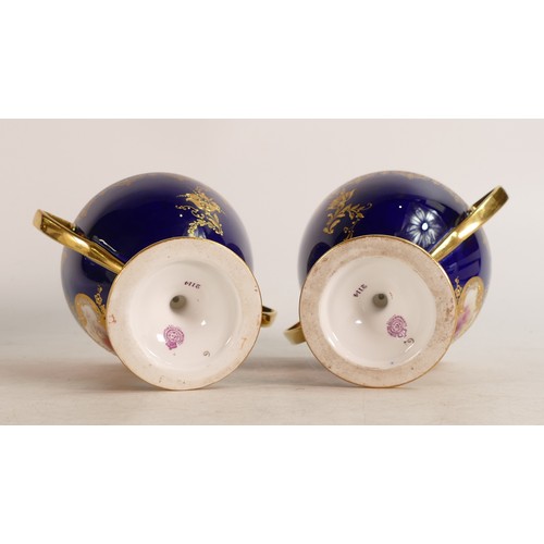 491 - A pair of Royal Worcester hand painted twin handled vases. Cobalt blue ground with Rococo cartouche ... 