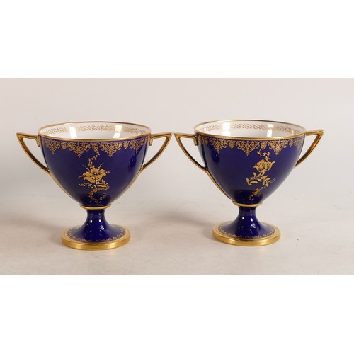 491 - A pair of Royal Worcester hand painted twin handled vases. Cobalt blue ground with Rococo cartouche ... 