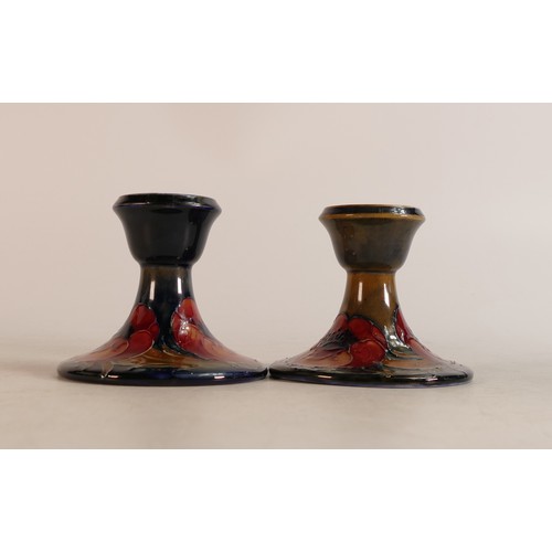 606 - Pair of William Moorcroft small candlesticks decorated in the Poppy design, h.10cm. (2)