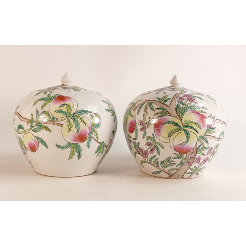 1662 - Two oriental lidded porcelain jars with painted decoration of Peaches. Height: 20cm (2)