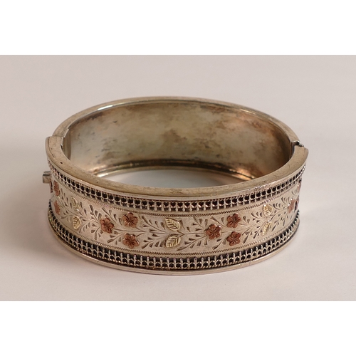 790 - Silver bangle with yellow metal floral decoration,32.3g.