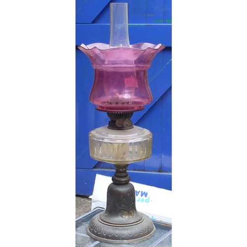 403 - Early 20th century Oil lamp with chimney and ill-fitting cranberry glass shade