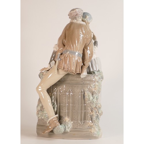 201 - Lladro Romeo & Juliet. An excellent figure group with Romeo sat on a wall embracing Juliet. In origi... 