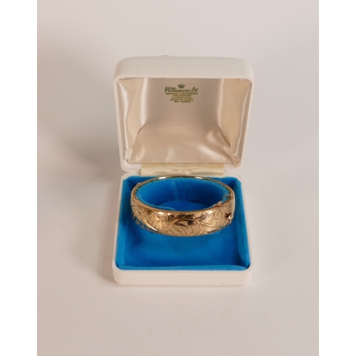 730 - 9ct gold bangle,decorated with scrolling foliage, 25.8g.