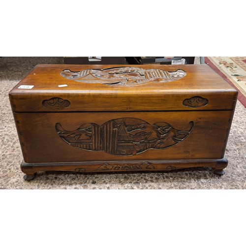 616 - A Small Chinese Camphor Wood Chest with Heavily Carved Oriental Scenes. Height: 32cm Length: 67cm De... 