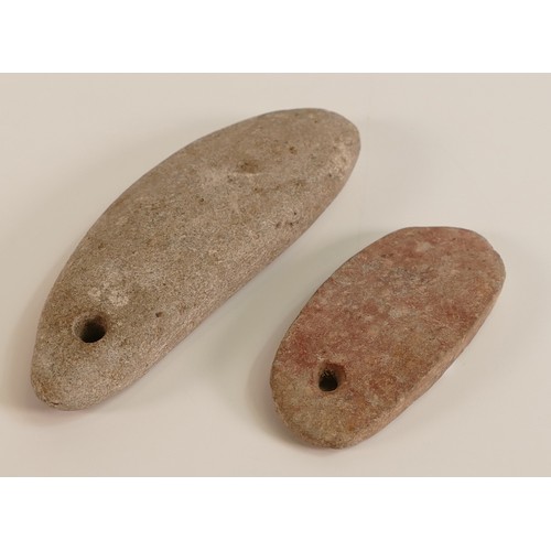 74 - Two Stone Axe Heads with pierced holes for the attaching of twine. Length of longest: 10.2cm