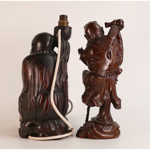 78 - Two Oriental hardwood figures, including Monk lamp and an Immortal figure atop a turtle. Height of t... 