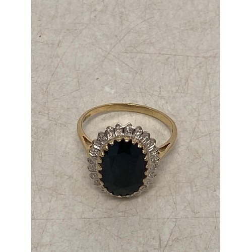 644 - 9ct gold ladies flamboyant dress ring, set with large oval dark blue stone surrounded by white stone... 