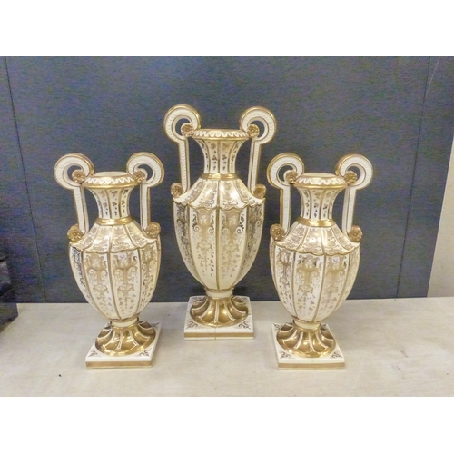 219 - A suite of three Davenport white and gilt twin handled vases,  some hairline cracks noted, height of... 