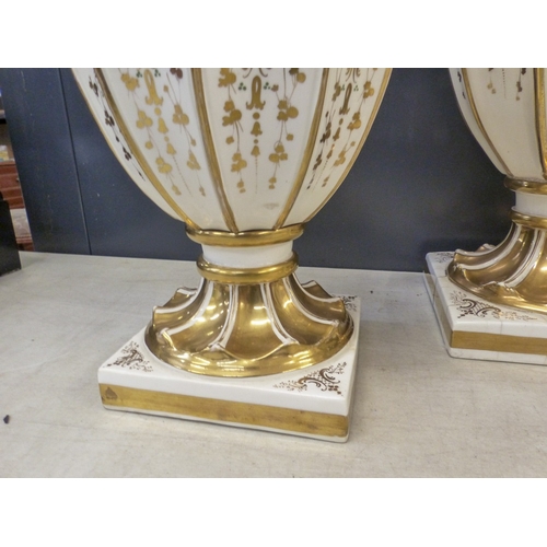 219 - A suite of three Davenport white and gilt twin handled vases,  some hairline cracks noted, height of... 