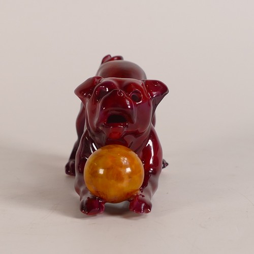 64 - Bernard Moore Flambe model of a dog playing with a yellow ball, L.11 x h.5.25cm.