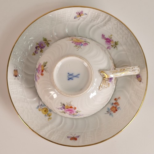 103 - Meissen, porcelain tea cup and saucer. Painted with floral and insect motifs on blanc white moulded ... 