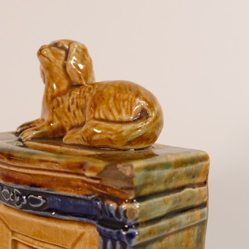 107 - 19th century Staffordshire Majolica money bank. Modelled as a mantlepiece with reclining dog above a... 