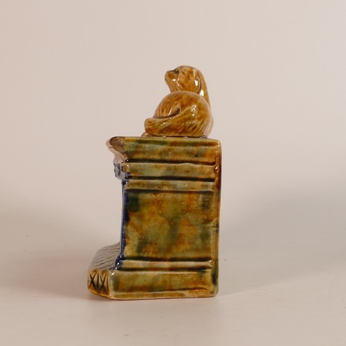 107 - 19th century Staffordshire Majolica money bank. Modelled as a mantlepiece with reclining dog above a... 