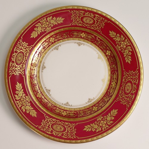 241 - Minton, seven heavily gilt plates. In red and light blue grounds with elaborate raised gilt patterns... 