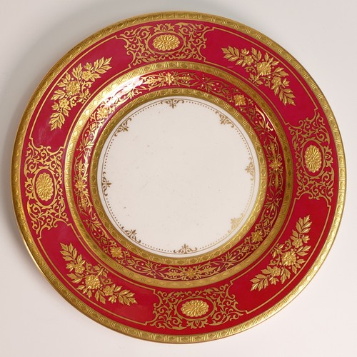 241 - Minton, seven heavily gilt plates. In red and light blue grounds with elaborate raised gilt patterns... 