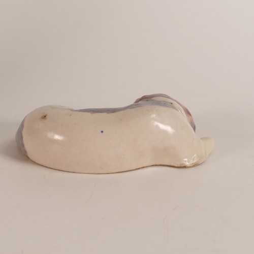 476 - Royal Doulton Lambeth, a rare stoneware model of a sleeping dog. In brown with semi-opaque glaze ove... 