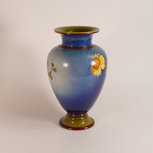 582 - Isabel Lewis for Doulton Lambeth, a Faience baluster vase decorated with sunflowers on blue ground, ... 