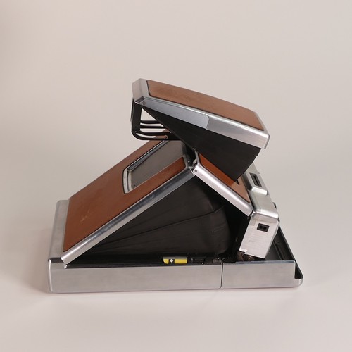 1154 - Polaroid SX-70 Land Camera. Chrome and tan covering. Includes original inserts. In Keystone leather ... 