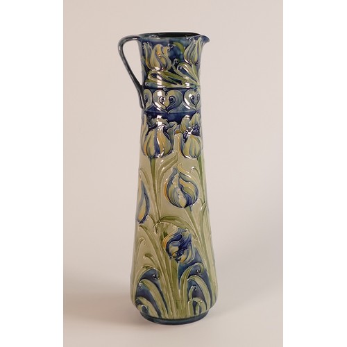 1203 - William Moorcroft Florian Ware jug, decorated with green & blue flowers on blue ground, made for Lib... 