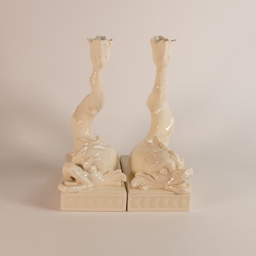 1351 - Wedgwood, a 20th century pair of Creamware Dolphin candlesticks. Modelled as a pair of rococo grotes... 