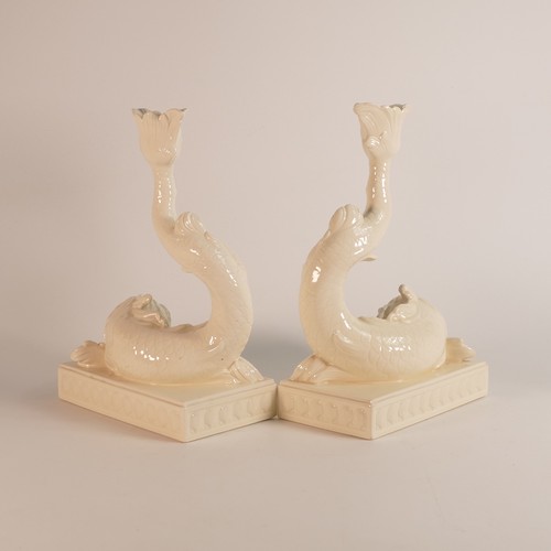 1351 - Wedgwood, a 20th century pair of Creamware Dolphin candlesticks. Modelled as a pair of rococo grotes... 