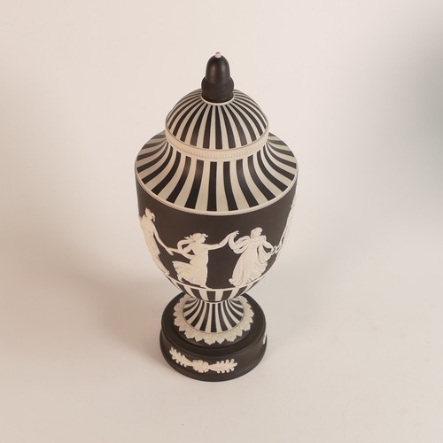 1355 - Wedgwood, dip black Jasperware 'Dancing Hours' vase and cover. Acorn finial lid on a sweeping should... 