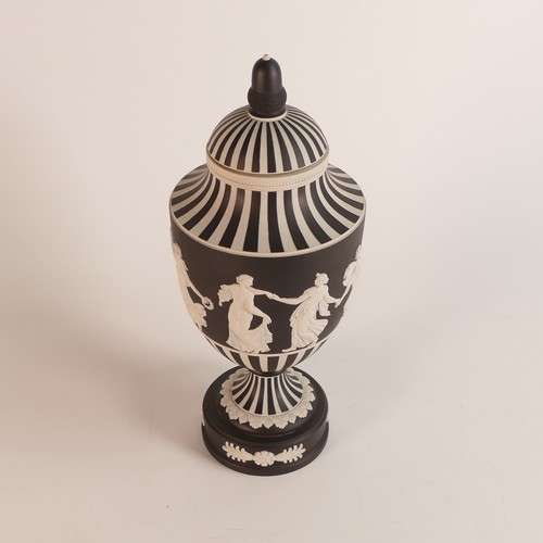 1356 - Wedgwood, dip black Jasperware 'Dancing Hours' vase and cover. Acorn finial lid on a sweeping should... 