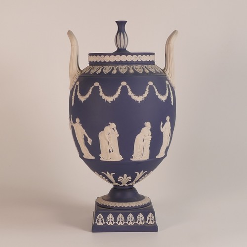 1388 - Wedgwood, dark blue Jasperware two handled urn & cover, classical relief scene to body. Impressed 'W... 