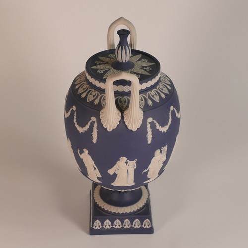 1388 - Wedgwood, dark blue Jasperware two handled urn & cover, classical relief scene to body. Impressed 'W... 