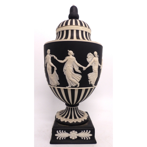 216 - Wedgwood black & white Jasperware urn & cover decorated in the dancing hours design, height 25cm.