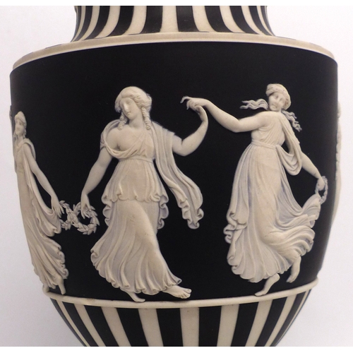 216 - Wedgwood black & white Jasperware urn & cover decorated in the dancing hours design, height 25cm.