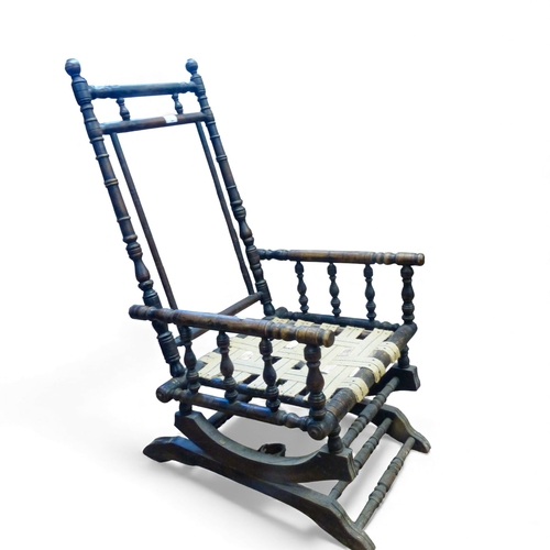 657 - Antique American oak bobbin turned rocking chair with seat webbing visible. H102cm x W54cm x D54cm