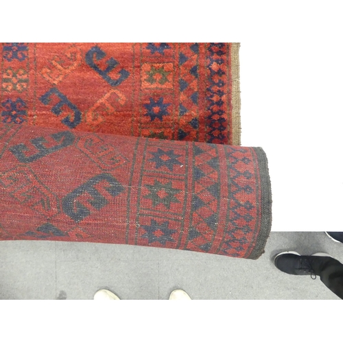 654 - Vintage Afghan tribal wool rug with a deep red field and navy blue accents, featuring a repeating oc... 